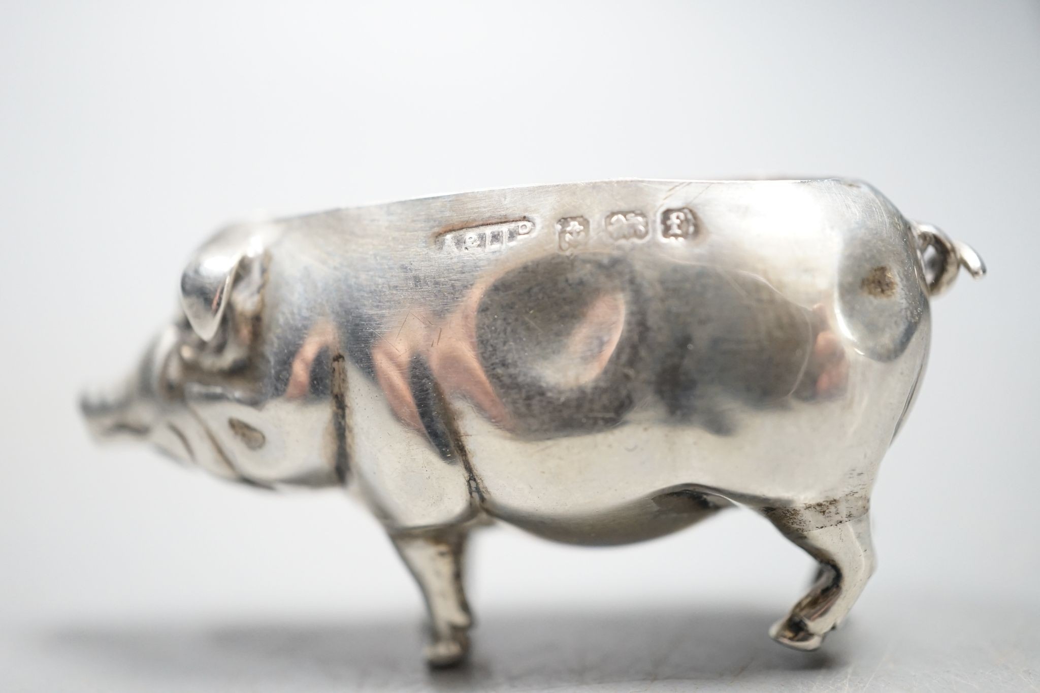 An Edwardian silver pig pin cushion, (lacking cushion), Adie & Lovekin Ltd, Birmingham, 1905, length 49mm.